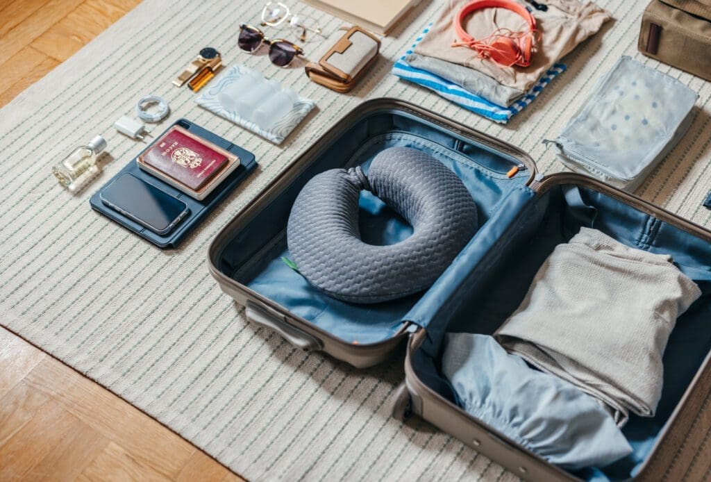 Open suitcase with travel essentials laid out.